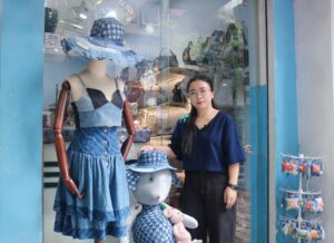 Chị Bùi Thị Kim Ngân - người sáng lập thương hiệu Renew Jeans trước một cửa hàng nhỏ của chị ở Hà Nội