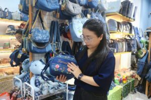 Chị Ngân đang giới thiệu một mẫu túi xách được làm từ quần jean cũ